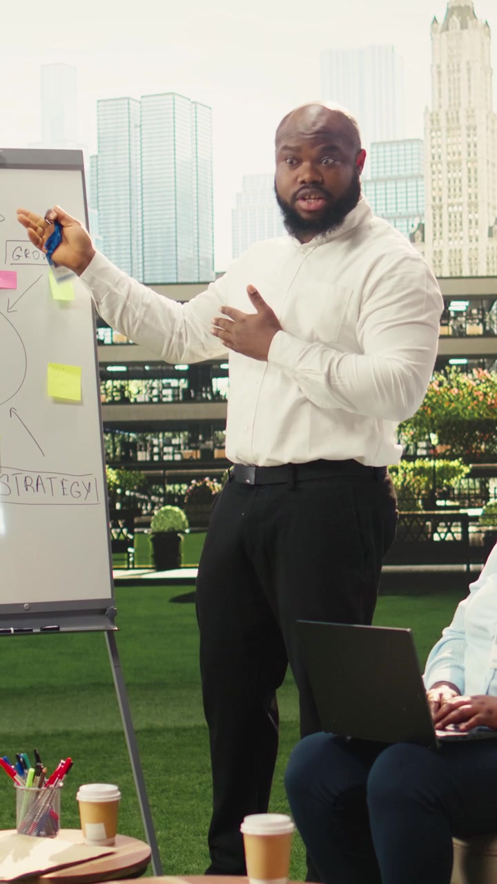 Vertical Video Diverse business team pointing at vision board with roadmap and sticky notes