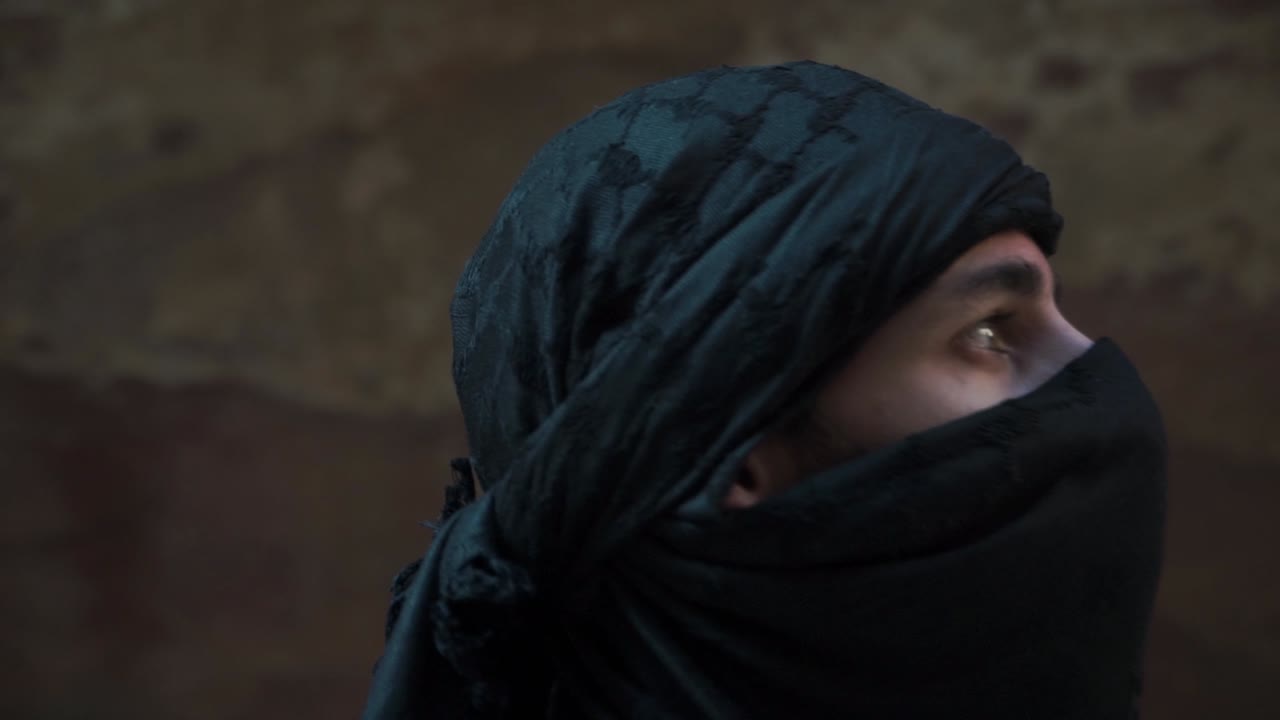 Male tourist wearing respectful head cover walking through wadi Petra Jordan