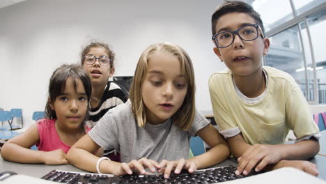 multiethnic kids looking at monitor and learning computer science