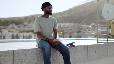 black man, relax and rest on wall with skateboard
