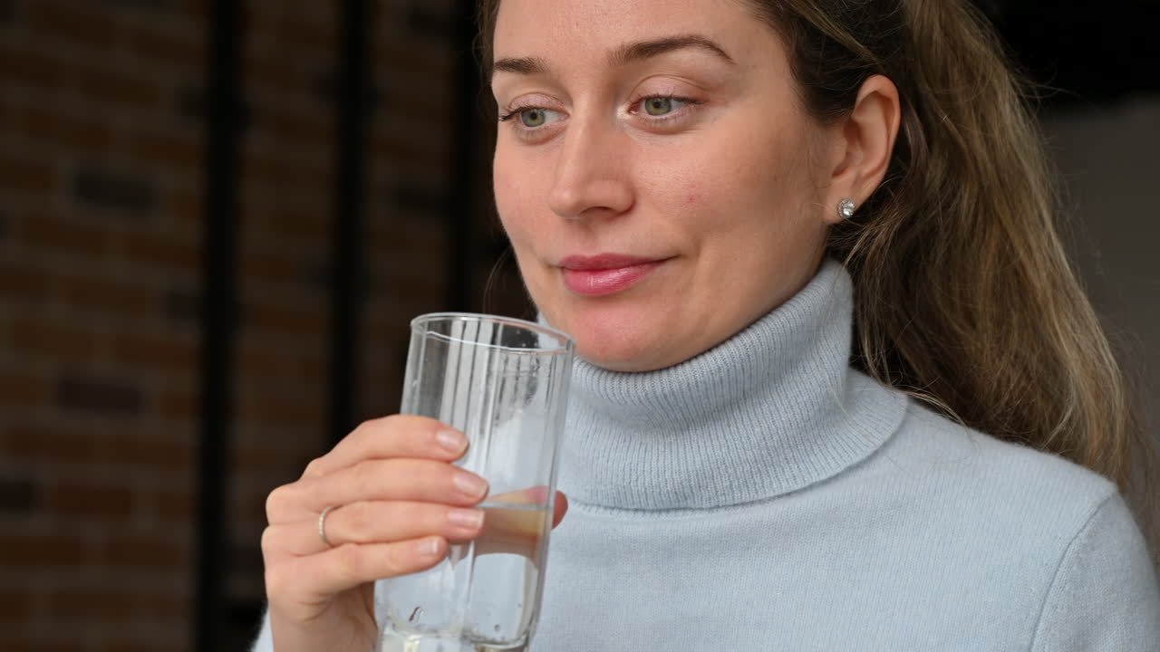 Woman drinking water from a glass at the office
