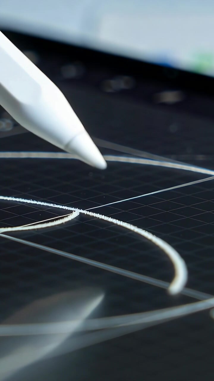 Vertical video: Touching stylus tracing curved guide strokes on grid tablet at desk, copy space