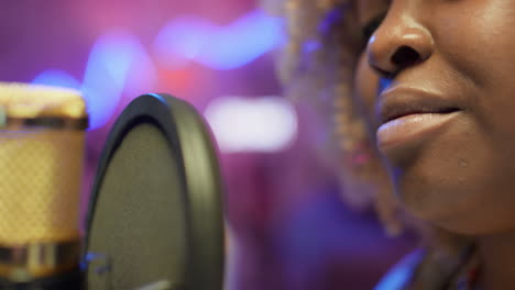 woman singing into a microphone in a recording studio