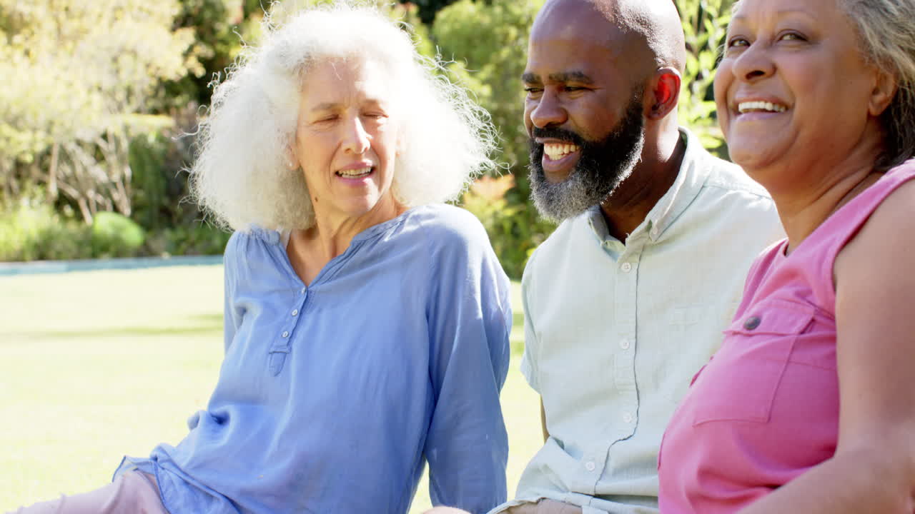 Smiling senior friends sitting outdoors, enjoying conversation and laughter together
