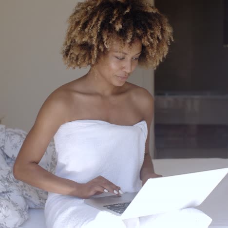 Young-Woman-Using-Laptop-On-Bed