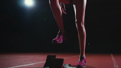 Female-hispanic-athlete-training-at-running-track-in-the-dark.-Slow-motion