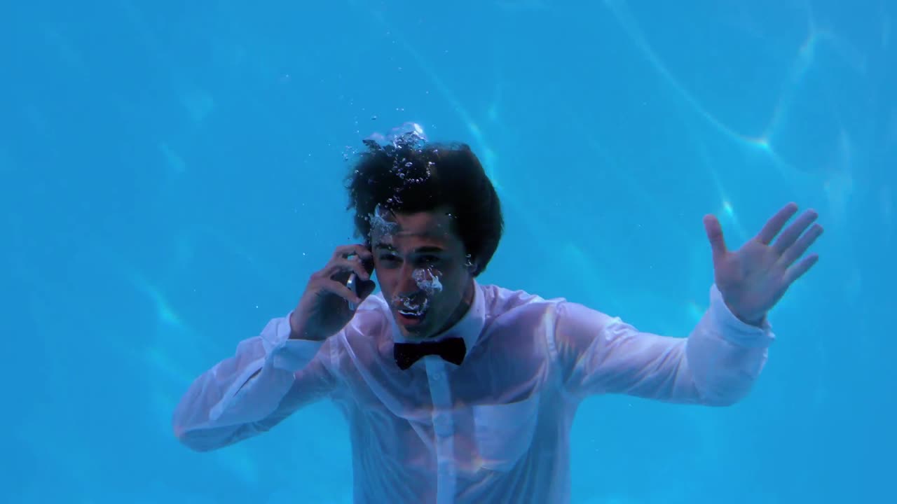 스마트 폰으로 이야기하는 수영장에서 물  ⁇ 에 있는 사업가