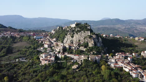 Wide-orbiting-aerial-shot-of-Bagnoli-del-Trigno-town-with-San-Silvestro-church-between-two-rock-spurs,-Isernia-and-Molise-region,-Italy,-4K