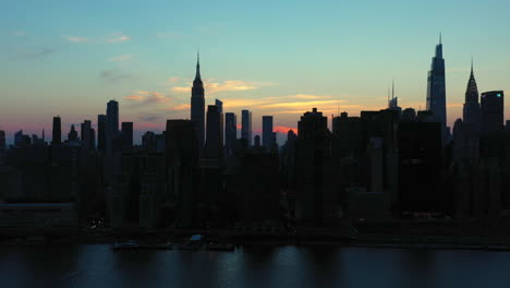 Larga-Y-épica-Toma-De-Camiones-Del-Legendario-Horizonte-Del-Centro-De-Manhattan-En-La-Hermosa-Puesta-De-Sol-Al-Atardecer