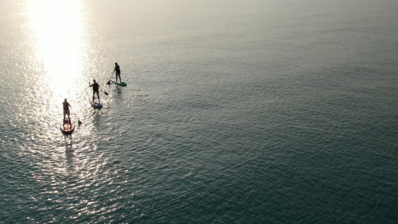 Woman paddleboarding at sunrise on the Gulf of Mexico