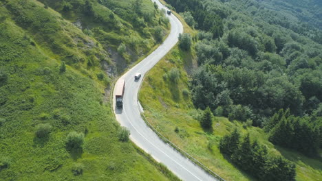 aerial view of truck driving through mountain pass