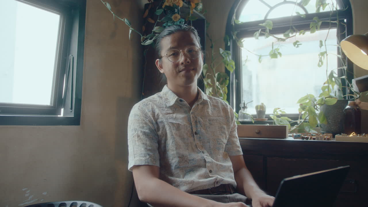 Portrait of Asian Man with Laptop in Antique Shop