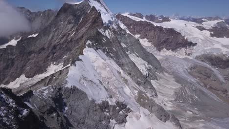 vista aérea desde un dron sobre la nieve en el valle inclinado hacia arriba para revelar pendientes empinadas y picos de montañas en los alpes