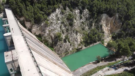 amazing water dam with people walking, lush green forest and sunny warm weather