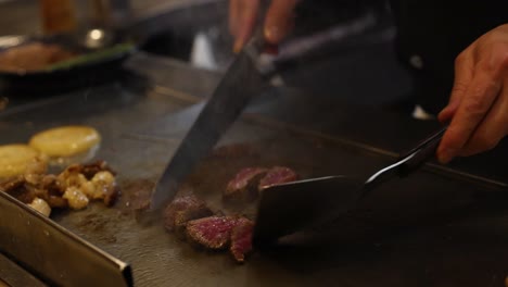 chef expertly prepares steak and sides on hot grill