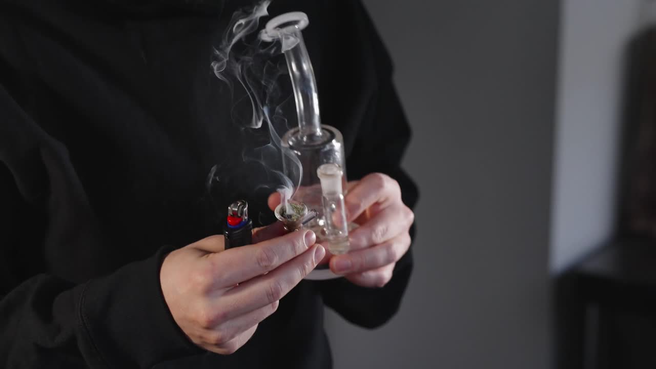 Illuminazione calda e accogliente di una scena con un uomo che fuma cannabis