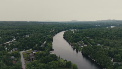 lush forest and coastal houses on the river magog in sherbrooke, quebec, canada