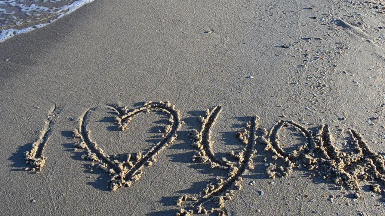 Love sign on sand, the beach. Shooting on the beach