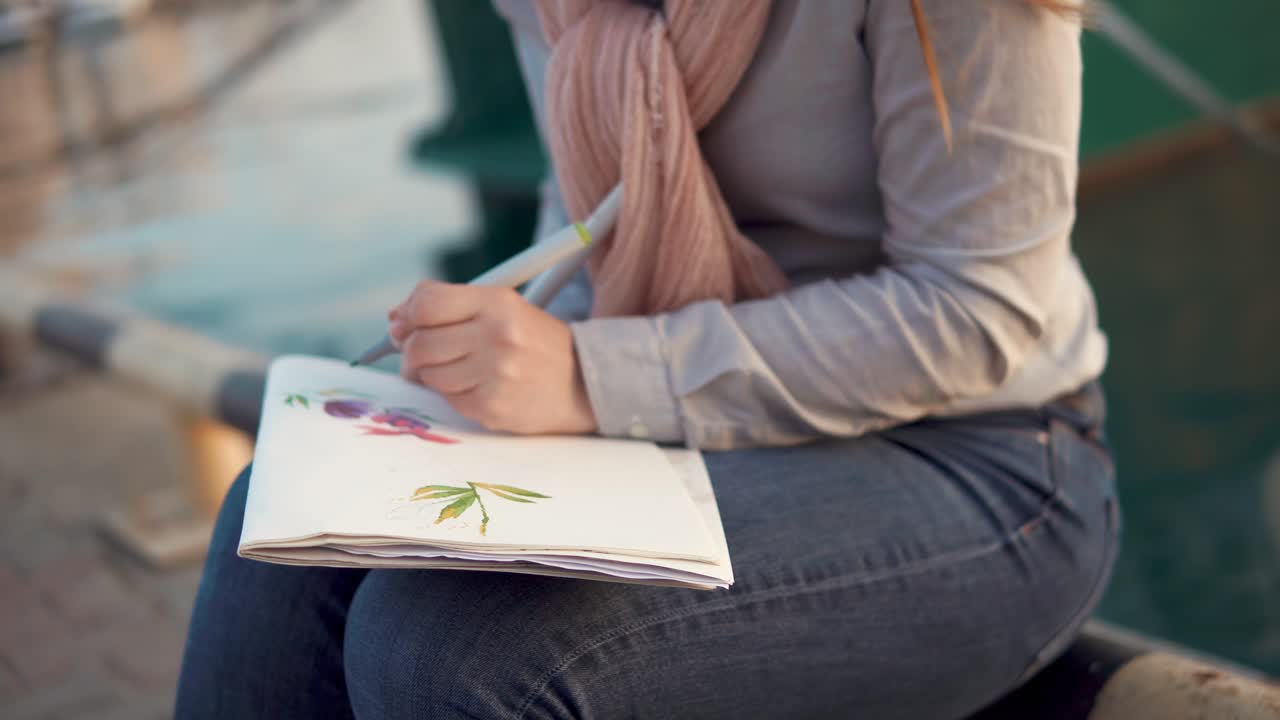 Woman sketching flowers by the harbor