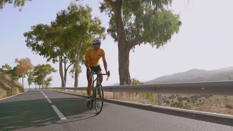 participando en ejercicio al aire libre, un hombre está en bicicleta en una bicicleta de carretera por una carretera vacía durante la mañana. el concepto de deportes extremos se captura en cámara lenta