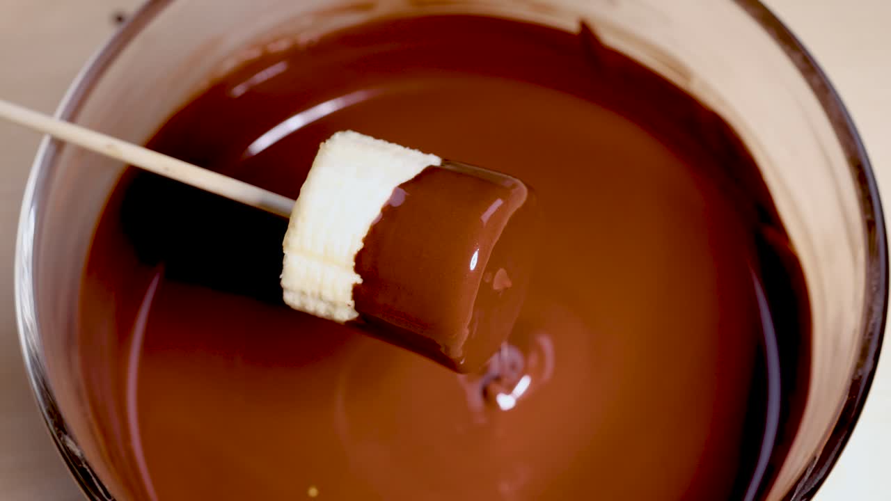 부드럽고 녹은 초콜릿에 담긴 바나나 조각