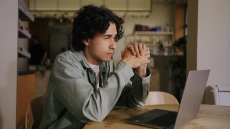 a young man working on his laptop in a cafe