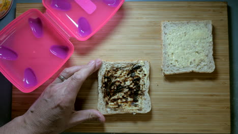 multigrain bread with margarine and an australian spread being scrapped onto the bread