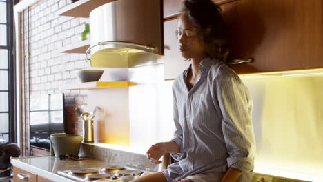 Women-using-mobile-phone-and-having-coffee-in-kitchen-4k