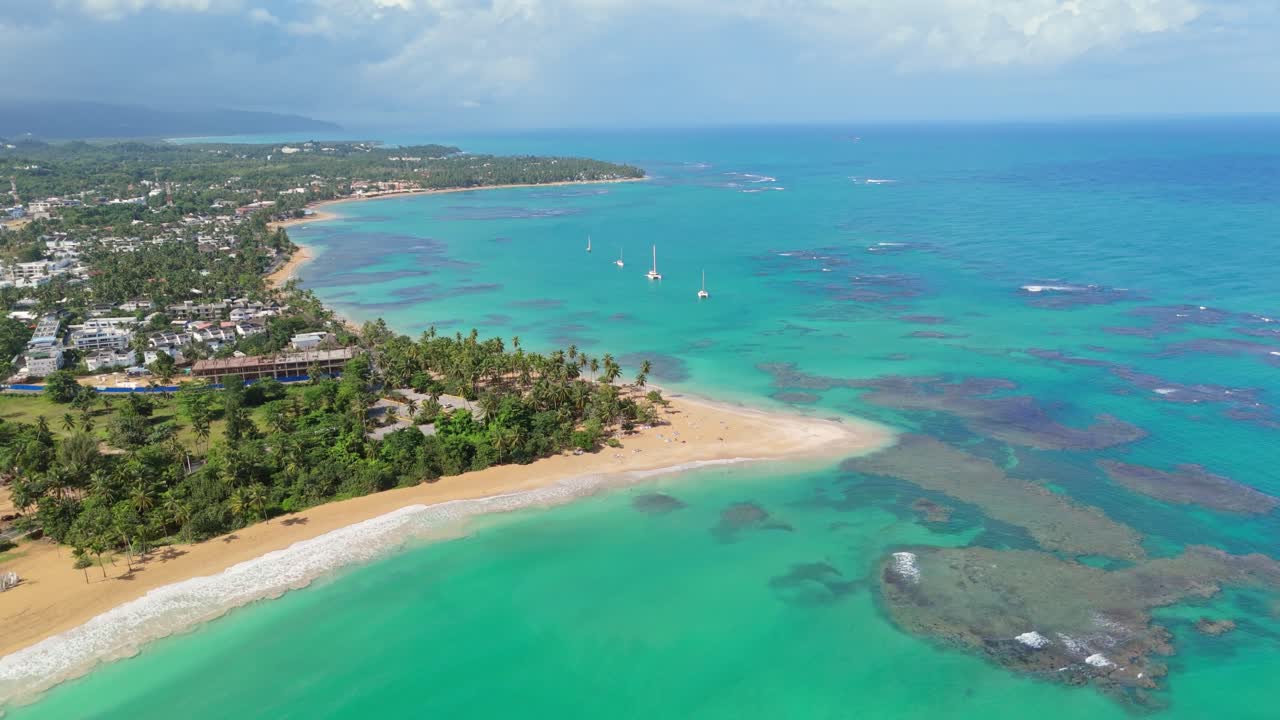 Backward shot at Punta Popy Beach, Las Terrenas, capturing the anchored boats and the stunning tropical landscape with the turquoise sea