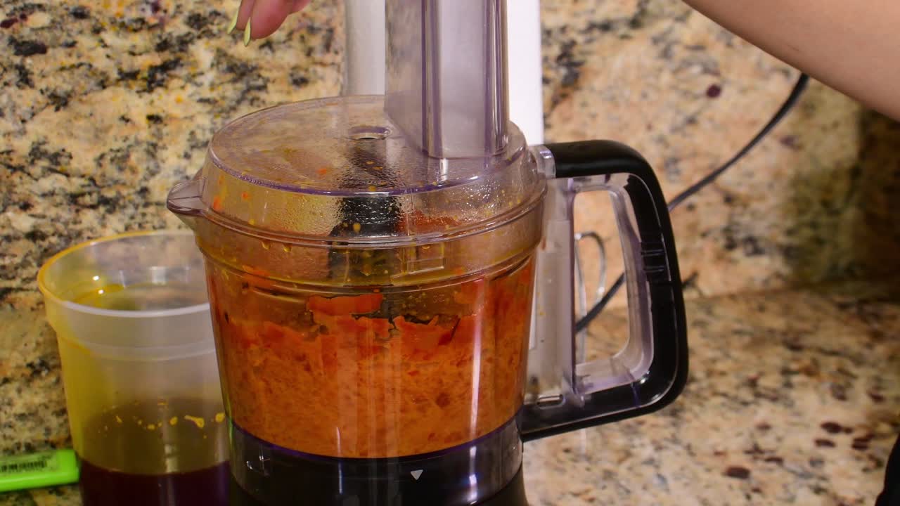 Primo piano di peperoncini ají lavorati in un frullatore con olio di annatto, per creare una vivace salsa tradizionale ed esaltare l'autentica cucina casalinga latinoamericana