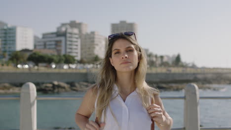 portrait of beautiful confident blonde woman on beachfront looking serious pensive