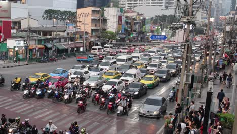 motorcycles and cars navigating a crowded intersection