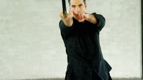 un luchador de kung fu practicando artes marciales con la espada 4k