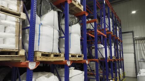 inside a warehouse: many shelves laden with neatly stacked pallets