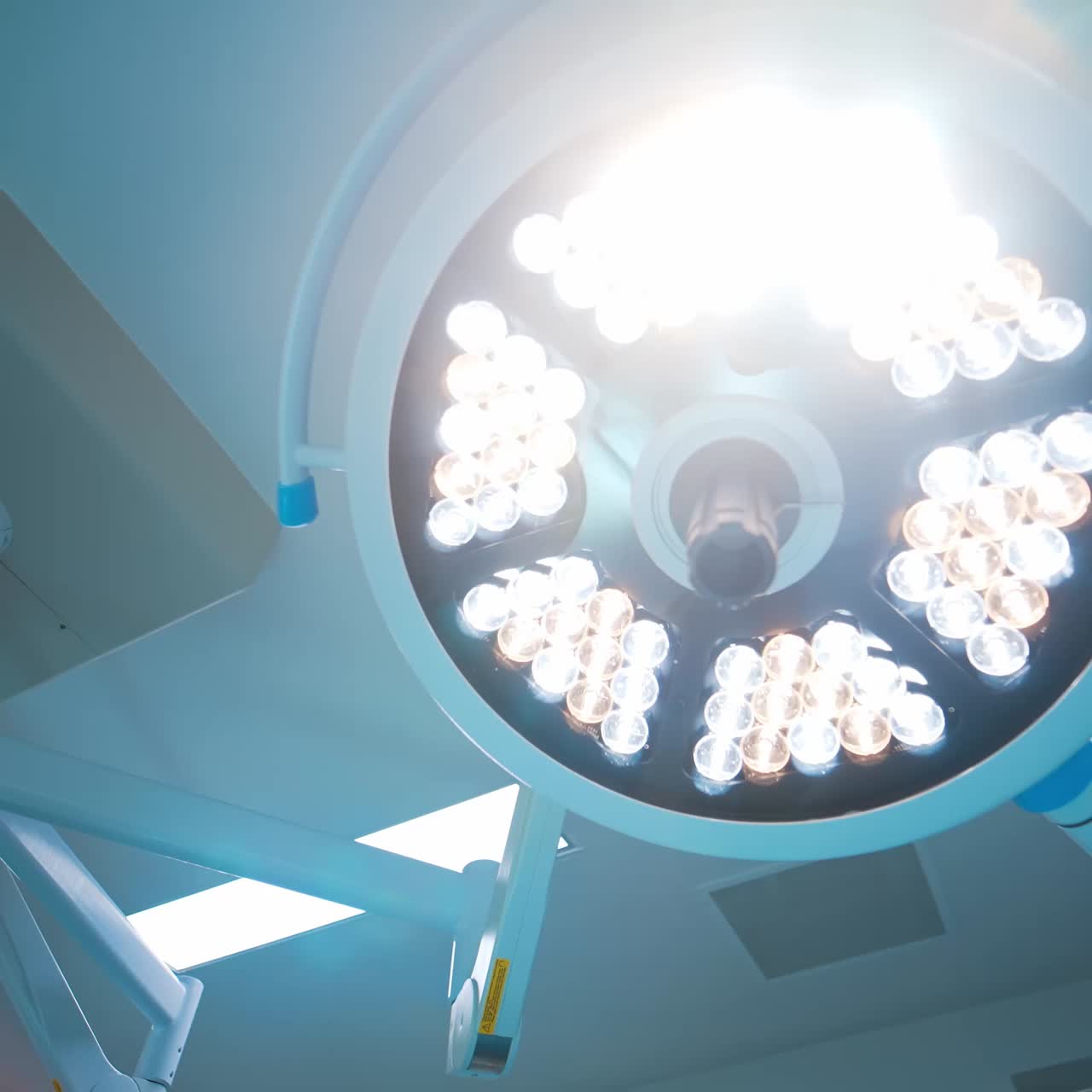 Lámpara redonda encendida en la sala de operaciones. Vista de ángulo bajo de la iluminación en el quirófano