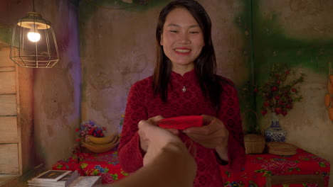 chinese new year celebration , pov housewife woman in traditional clothing receiving an envelope with money