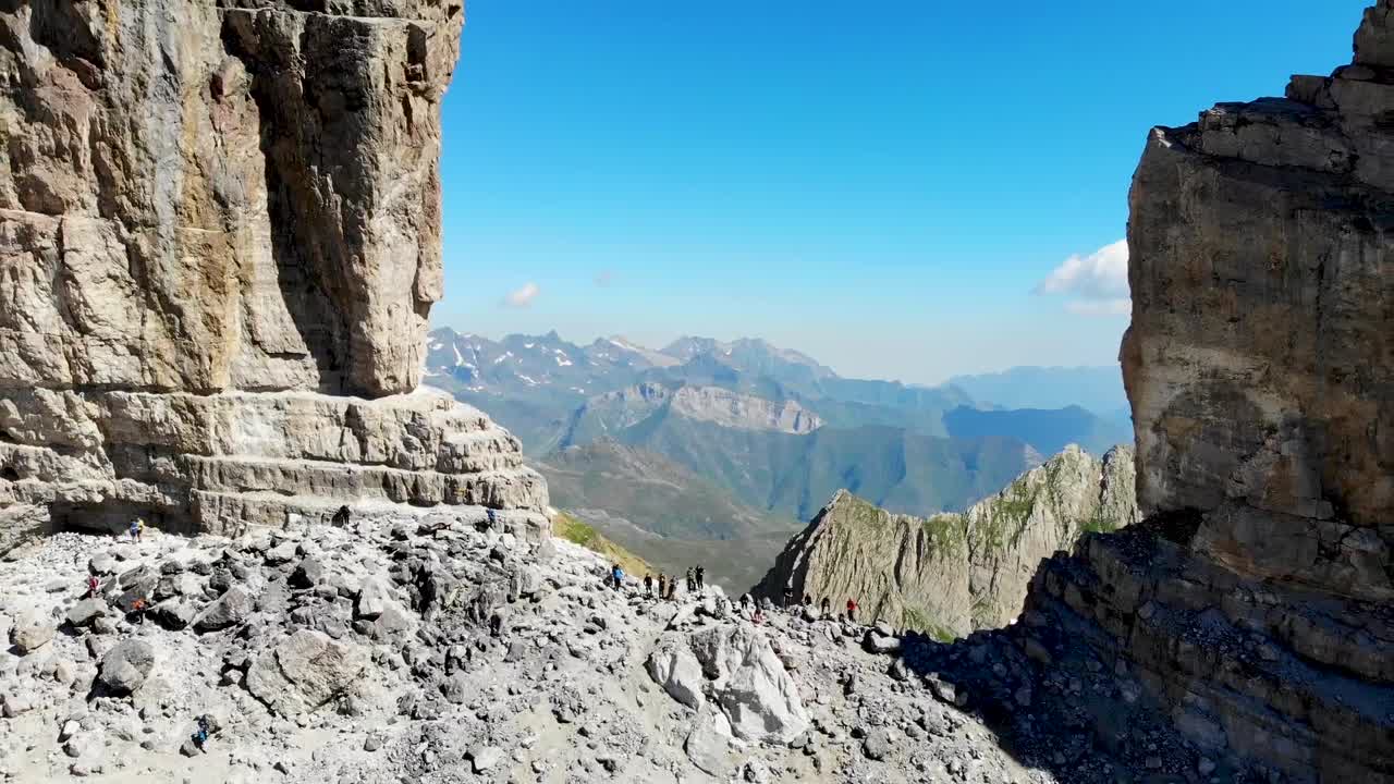 드론은 다른 산의 넓은 전망과 함께 큰 바위와 눈 위로 날아갑니다 - ordesa