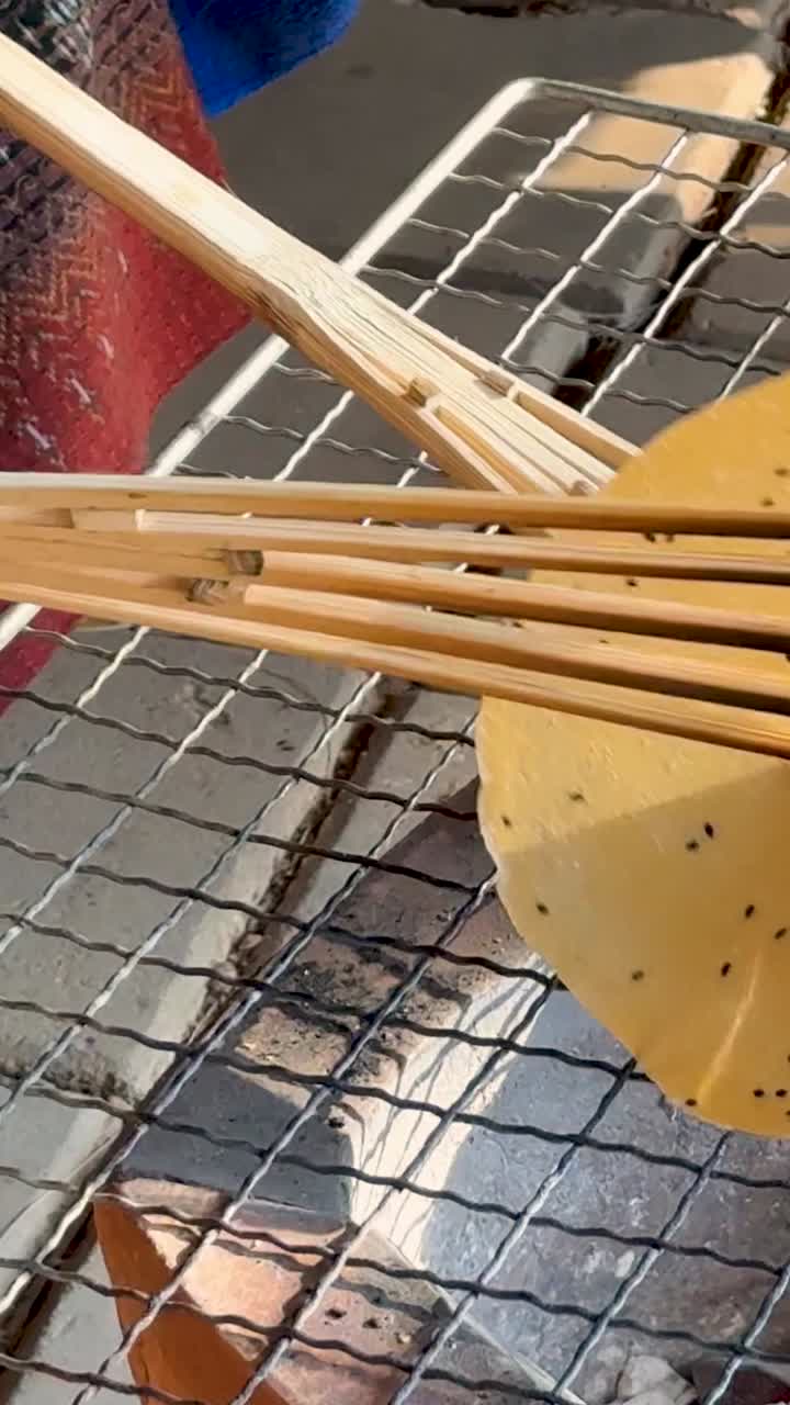 Rice cracker grilling on open flame in Thailand