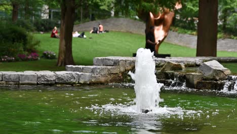 water fountain in a green park with people