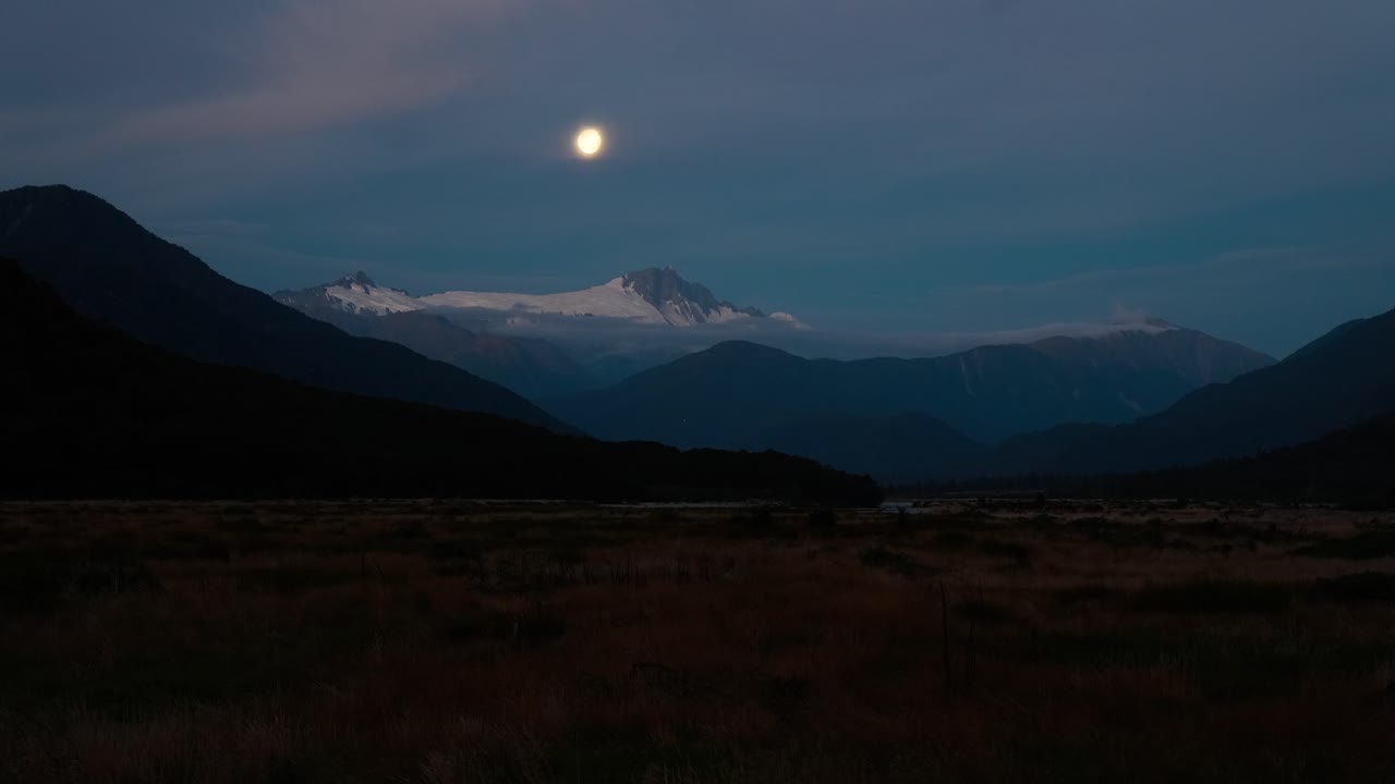 Time lapse della luna che si muove sopra il monte Hooker innevato nel paesaggio della Nuova Zelanda.