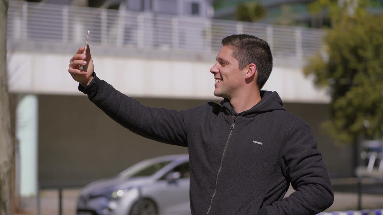 hombre feliz tomando una selfie con un teléfono inteligente en la calle