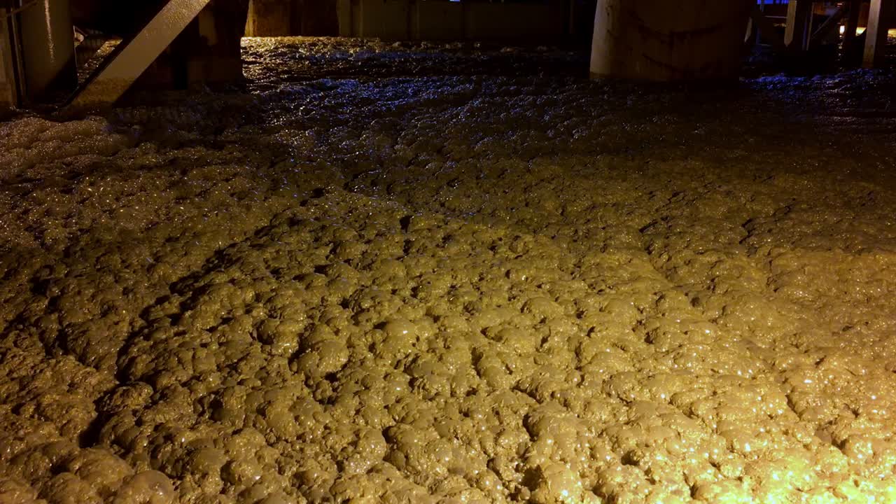 toma manual del cieno que flota sobre el agua del océano desde el interior de una draga