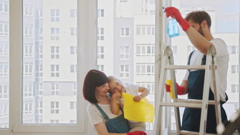 familia limpiando ventanas juntos