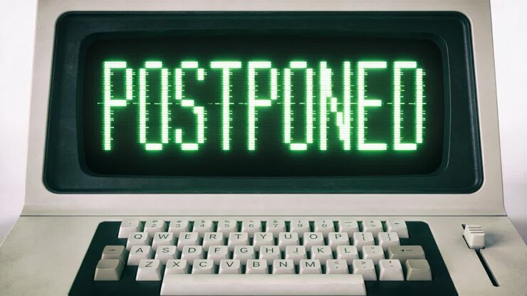 Displaying CRT screen showing POSTPONED and flickering from glitch at desk with beige keys, slider