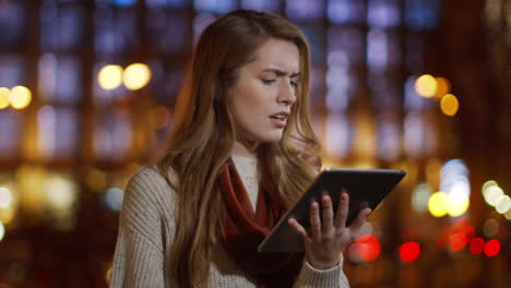 mujer molesta usando la tableta al aire libre. chica confundida mirando la pantalla de la tableta al aire libre.