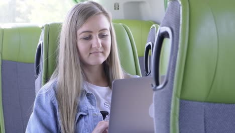 professional young businesswoman wearing a light blue shirt, conversing on her smartphone while using a laptop in a modern office. she looks focused and cheerful