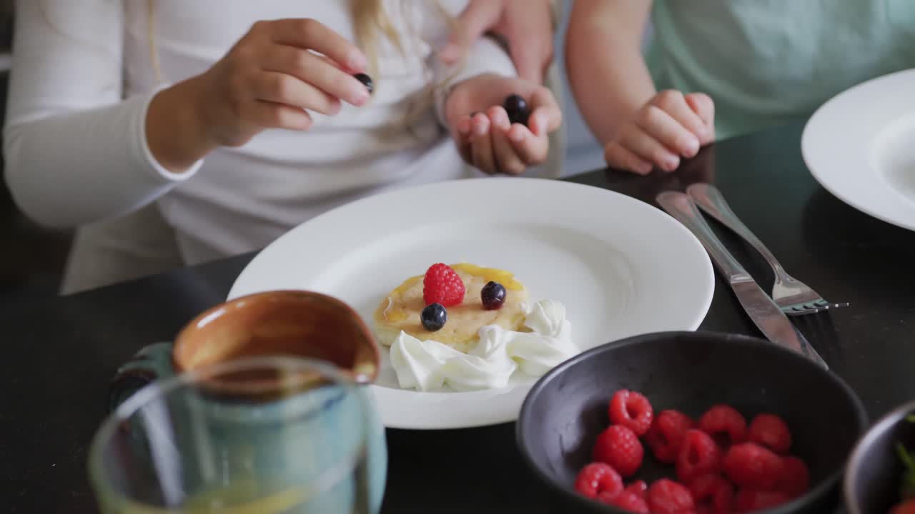 Famiglia che guarnisce il cibo a tavola in una casa accogliente 4k