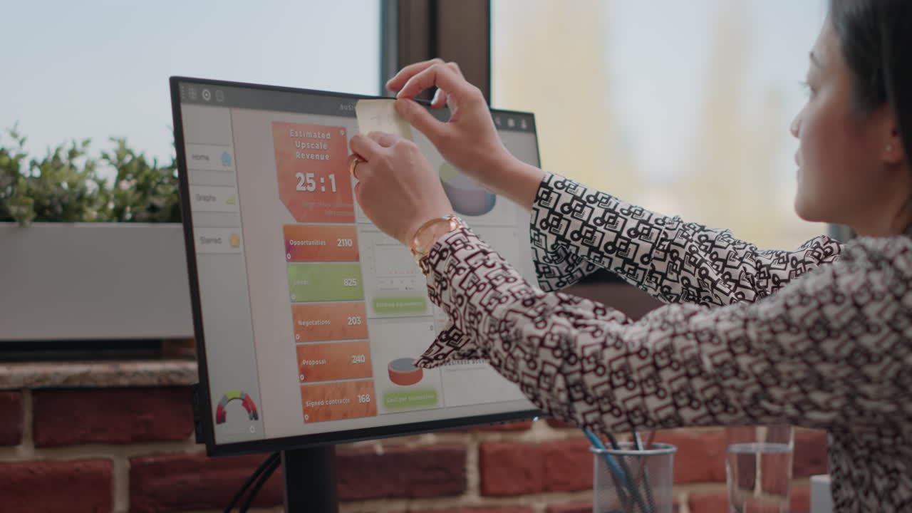 Close up of worker putting sticky notes on computer