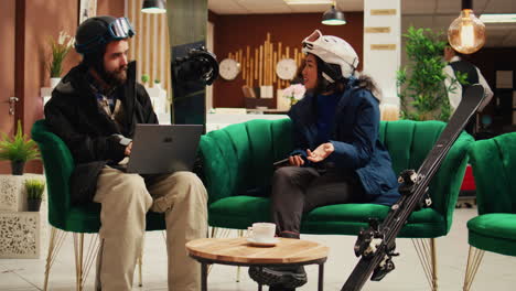 focused couple using gadgets in lobby