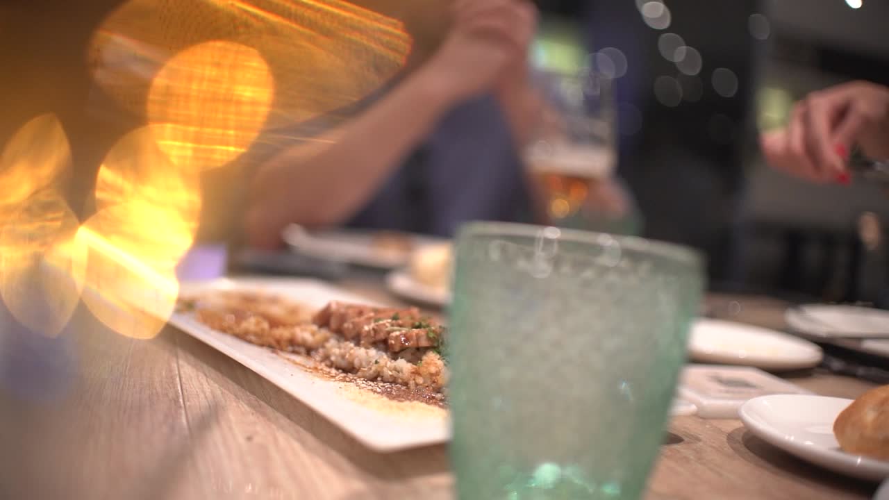 amigos comiendo en el restaurante celebrando cumpleaños en el comedor, tostadas, vítores y preparando su propia carne en piedra caliente
